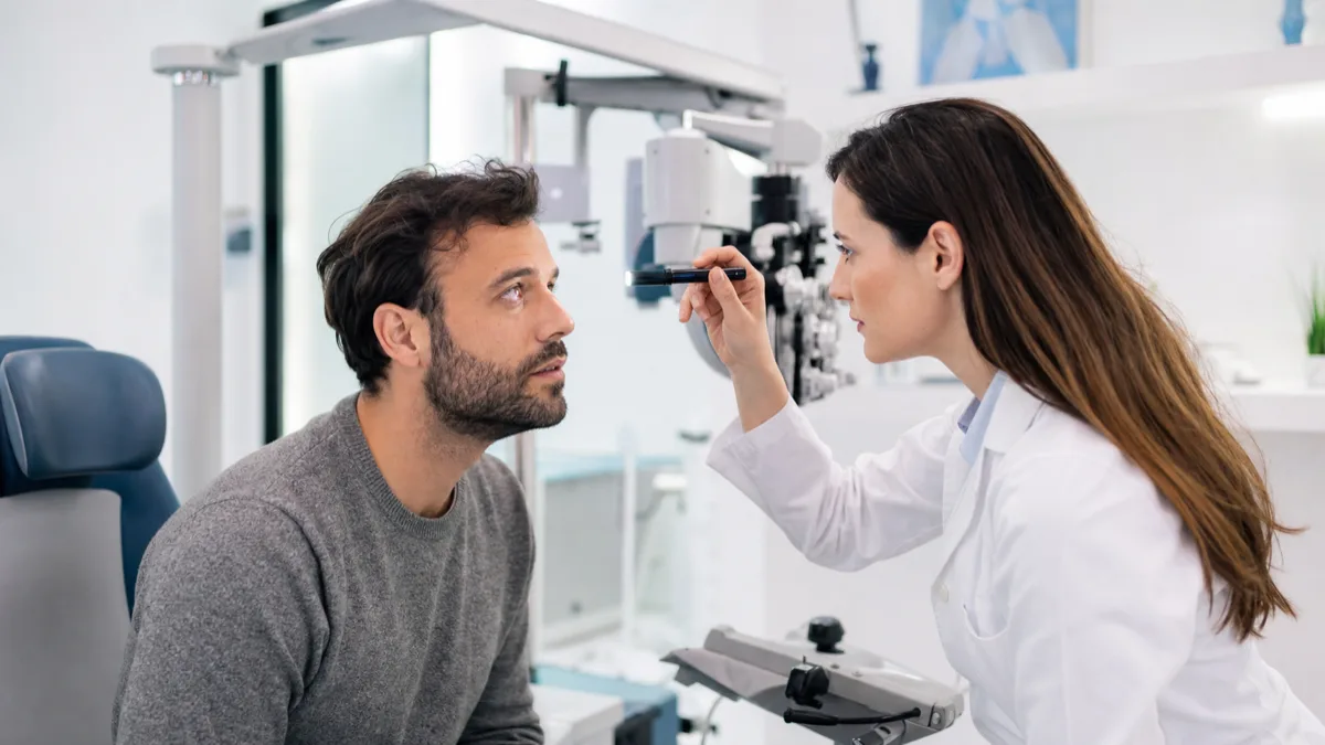 Optometrist examining a patient's eye during an urgent eye care visit